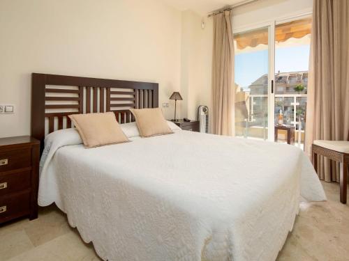 a bedroom with a large white bed and a window at Apartamento Tamarindo - Ubicación Premium Frente a la Playa con Piscina in Denia