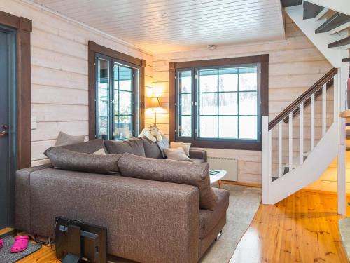 ein Wohnzimmer mit einer Couch und einer Treppe in der Unterkunft Holiday Home Tahkomäki by Interhome in Nilsiä