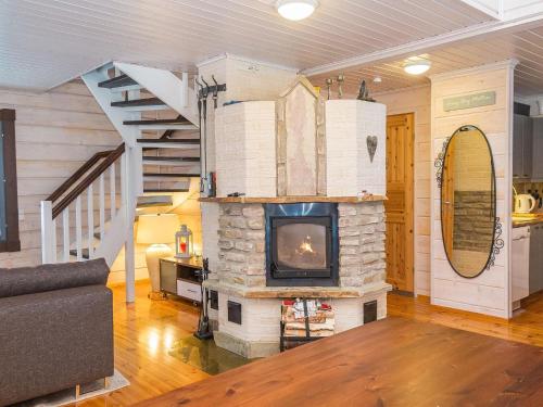 ein Wohnzimmer mit Kamin und Treppe in der Unterkunft Holiday Home Tahkomäki by Interhome in Nilsiä