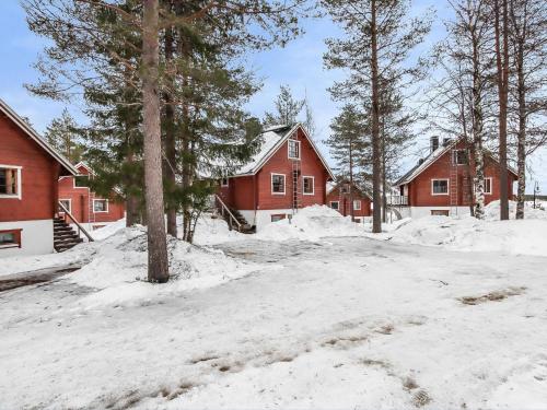 einen schneebedeckten Hof mit Häusern und Bäumen in der Unterkunft Holiday Home Alppikylä 4a paritalo by Interhome in Hyrynsalmi