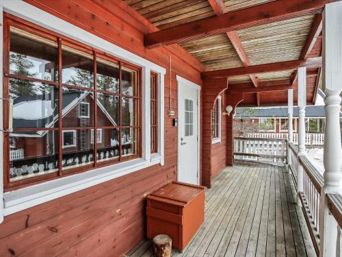 eine Veranda eines Holzhauses mit einer Bank darauf in der Unterkunft Holiday Home Alppikylä 4a paritalo by Interhome in Hyrynsalmi