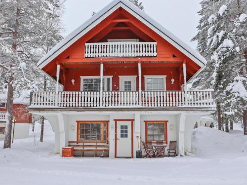 ein rotes Haus mit Balkon im Schnee in der Unterkunft Holiday Home Alppikylä 4b paritalo by Interhome in Hyrynsalmi