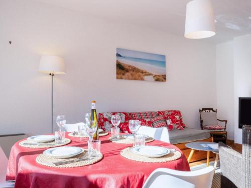 une salle à manger avec une table avec une nappe rouge dans l'établissement Apartment La Sauvagère-2 by Interhome, à Carnac