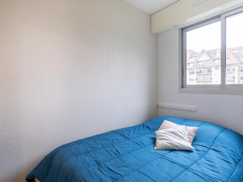 une chambre avec un lit bleu avec une fenêtre dans l'établissement Apartment Les Normandières-23 by Interhome, à Cabourg