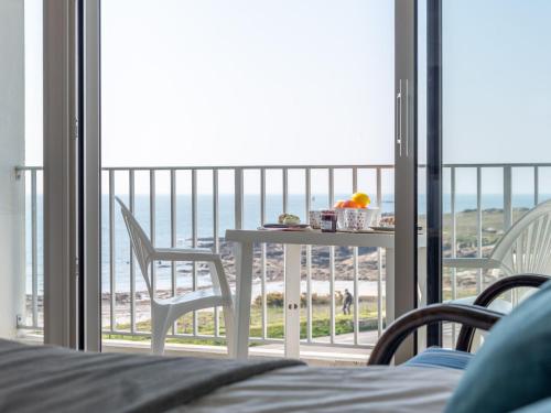 a bedroom with a balcony with a table and chairs at Apartment Les Trois Iles-10 by Interhome in Quiberon