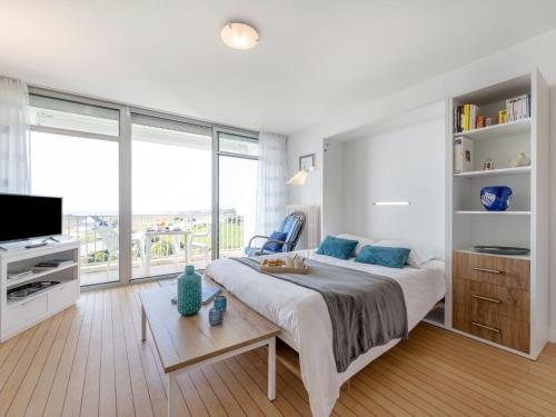 a bedroom with a large bed and a large window at Apartment Les Trois Iles-10 by Interhome in Quiberon