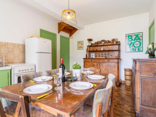 a dining room with a wooden table and a kitchen at Holiday Home GACHOUNENEA by Interhome in Bidart