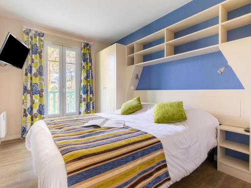 - une chambre avec un lit aux murs bleus et des oreillers verts dans l'établissement Holiday Home Domaine Golf Resort-3 by Interhome, à Lacanau-Océan