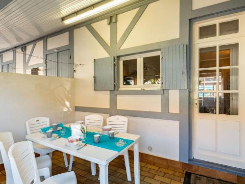 a dining room with a white table and chairs at Holiday Home Agur by Interhome in Mimizan