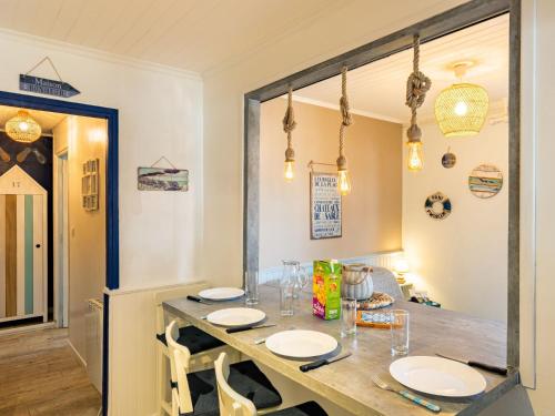 d'une salle à manger avec une table recouverte de plaques blanches. dans l'établissement Holiday Home Agur by Interhome, à Mimizan