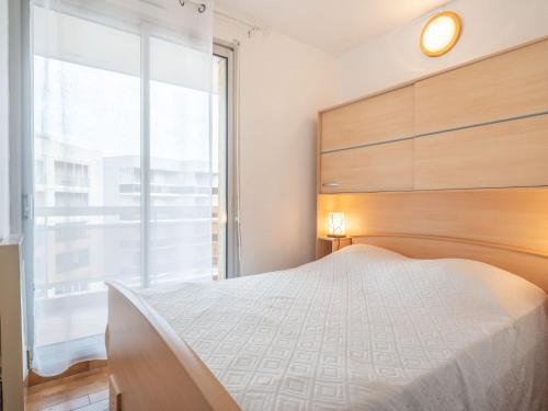 une chambre avec un grand lit et une grande fenêtre dans l'établissement Apartment Les Balcons de la Plage-5 by Interhome, à Canet