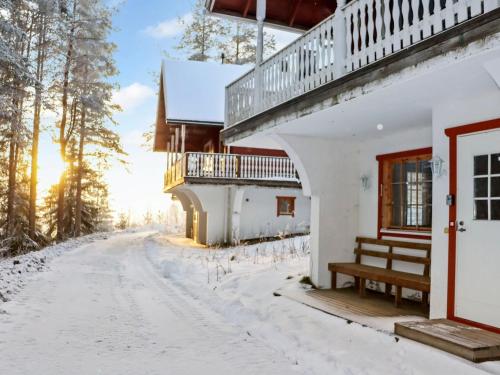 a house in the snow with a bench at Holiday Home Alppikylä 8b paritalo by Interhome in Hyrynsalmi