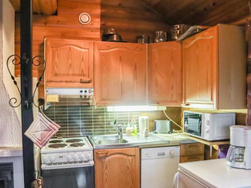 eine Küche mit Holzschränken und einer Spüle in der Unterkunft Holiday Home Alppi 6a paritalo by Interhome in Hyrynsalmi