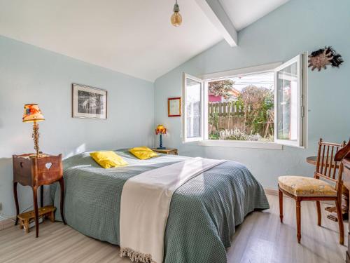 ein Schlafzimmer mit einem Bett und zwei Fenstern in der Unterkunft Holiday Home Milady by Interhome in Biarritz