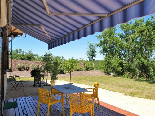 a patio with a table and chairs on a deck at Holiday Home L'Orme by Interhome in Loupiac