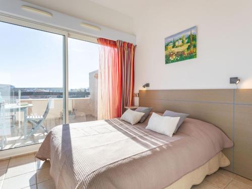 une chambre avec un lit et une grande fenêtre dans l'établissement Apartment Les Reflets-3 by Interhome, à Saint-Cyprien
