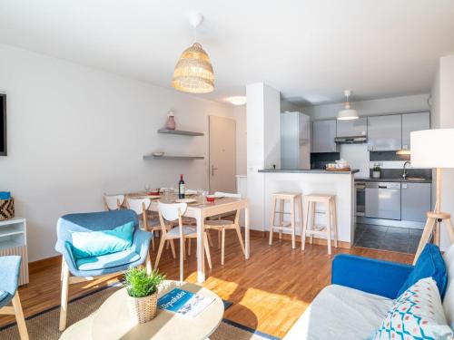 ein Wohnzimmer und eine Küche mit einem Tisch und Stühlen in der Unterkunft Apartment Les Jardins d'Oihana by Interhome in Bidart