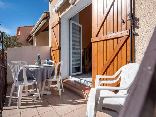 - une table et des chaises sur une terrasse avec une porte dans l'établissement Holiday Home Mas de l'Ile by Interhome, au Barcarès