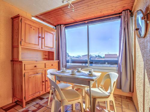 une salle à manger avec une table et des chaises et une fenêtre dans l'établissement Apartment Les Mas de La Mer-10 by Interhome, à Saint Cyprien Plage