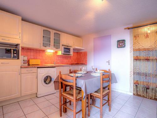 une cuisine avec une table, des chaises et un évier dans l'établissement Apartment Les Mas de La Mer-10 by Interhome, à Saint Cyprien Plage