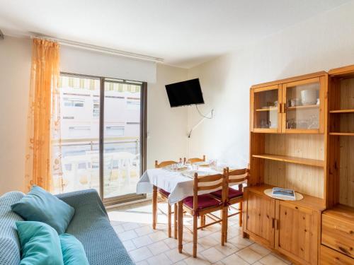 een woonkamer met een tafel en een televisie bij Apartment Saint James-11 by Interhome in Le Lavandou