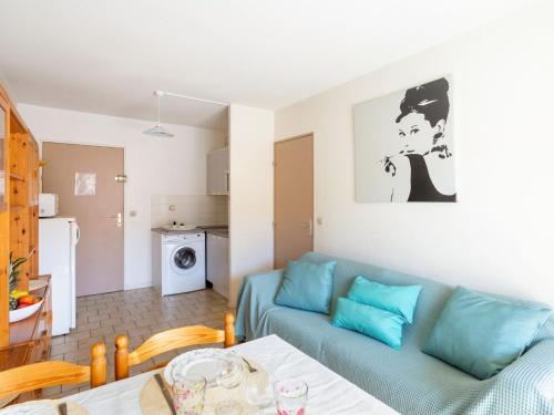 un salon avec un canapé bleu et une cuisine dans l'établissement Apartment Saint James-11 by Interhome, au Lavandou