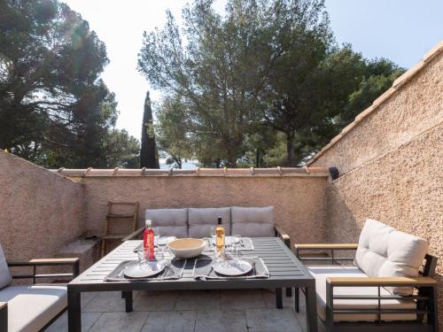 un patio avec une table et des chaises sur un balcon dans l'établissement Apartment Les Hauts du Port-2 by Interhome, à Saint-Cyr-sur-Mer