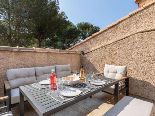 - une table et des chaises sur la terrasse dans l'établissement Apartment Les Hauts du Port-2 by Interhome, à Saint-Cyr-sur-Mer