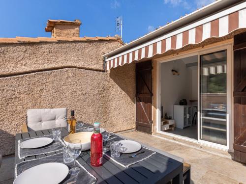 - une table avec des assiettes et des verres à vin sur la terrasse dans l'établissement Apartment Les Hauts du Port-2 by Interhome, à Saint-Cyr-sur-Mer