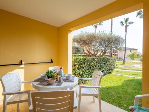 - une table et des chaises sur une terrasse avec vue sur la cour dans l'établissement Apartment Les Rivages des Issambres-7 by Interhome, aux Issambres