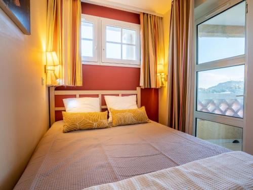 - une chambre avec un lit avec deux oreillers et une fenêtre dans l'établissement Apartment Le Belvédère - D4 256 by Interhome, à Agay