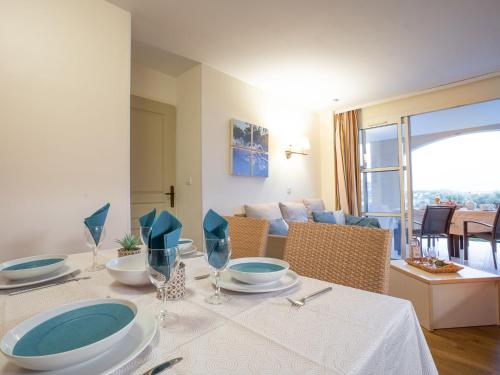 une table à manger avec une nappe blanche et des assiettes bleues dans l'établissement Apartment Le Belvédère - V2 013 by Interhome, à Agay