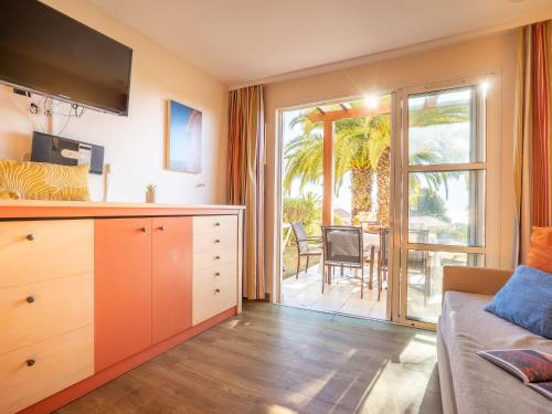 - un salon avec un lit et une porte coulissante en verre dans l'établissement Apartment Le Village - C4 010 by Interhome, à Agay