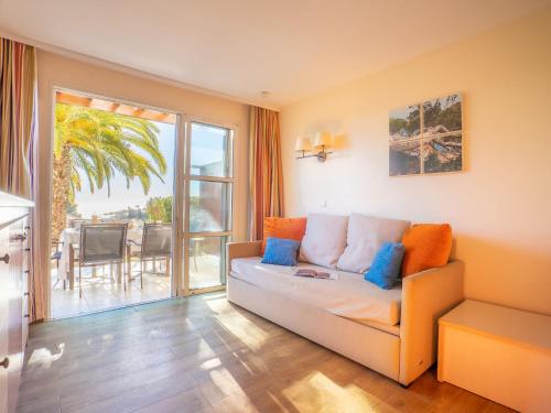 d'un salon avec un canapé et un balcon. dans l'établissement Apartment Le Village - C4 010 by Interhome, à Agay