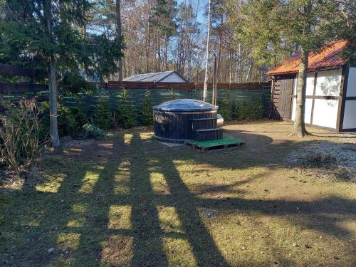 een achtertuin met een grote houten structuur in de tuin bij dom całoroczny na Kaszubach Nietoperek, prywatna balia, bania ruska, prywatna sauna in Załakowo