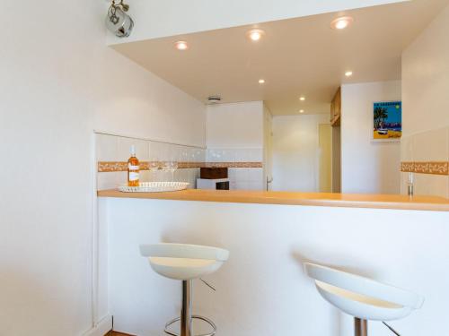- une cuisine avec des murs blancs et deux tabourets dans l'établissement Apartment le Port de Bormes-5 by Interhome, à Bormes-les-Mimosas