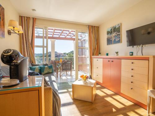 Il dispose d'une cuisine et d'un salon avec vue sur un patio. dans l'établissement Apartment L'Esquinade - J4 332 by Interhome, à Agay