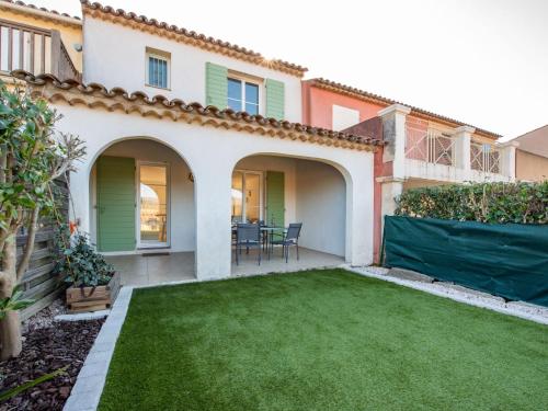 a backyard with a green lawn in front of a house at Holiday Home Lou Cepoun by Interhome in Cogolin