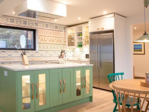 a kitchen with green cabinets and a table at Holiday Home 10 Husabost by Interhome in Husabost