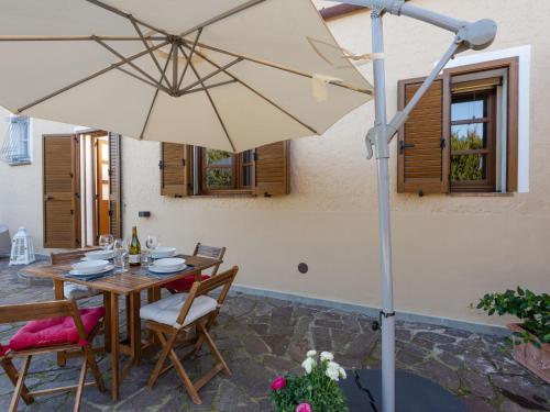een patio met een tafel en een parasol bij Apartment Benedetta by Interhome in Castiglione della Pescaia