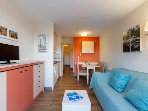 un salon avec un canapé bleu et une cuisine dans l'établissement Apartment L'Esquinade F6 225 by Interhome, à Agay