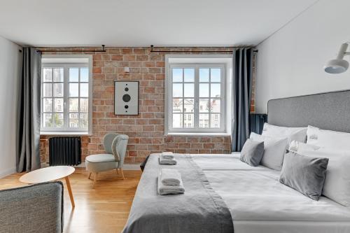 a bedroom with a bed and a brick wall at Downtown Apartments Old Town Szeroka in Gdańsk