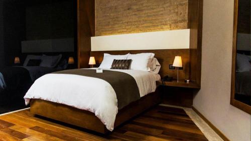 a bedroom with a large bed and two lamps at Hotel Boutique Casa Madero in Morelia