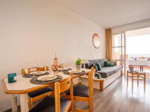 une salle à manger avec une table et un canapé dans l'établissement Apartment Le Village - E1212 by Interhome, à Agay