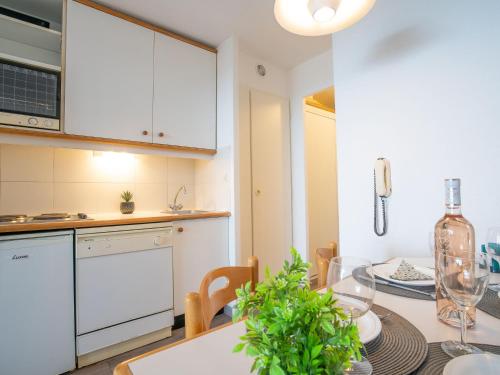 une cuisine avec une table avec une bouteille de vin dans l'établissement Apartment Le Village - E1212 by Interhome, à Agay