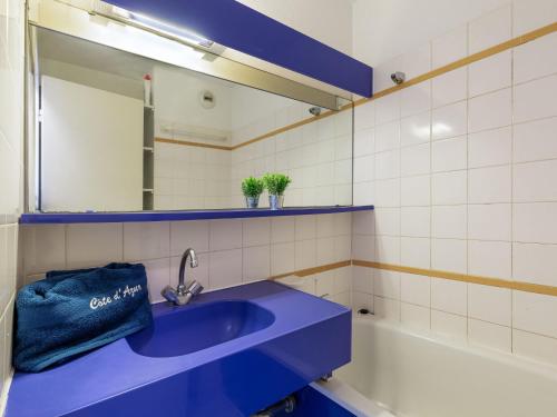 La salle de bains est pourvue d'un lavabo bleu et d'une baignoire. dans l'établissement Apartment L'Esquinade - FH 012 by Interhome, à Agay