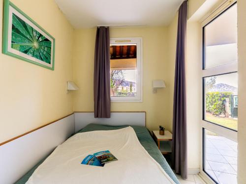 une petite chambre avec un lit et une fenêtre dans l'établissement Apartment L'Esquinade - FH 012 by Interhome, à Agay