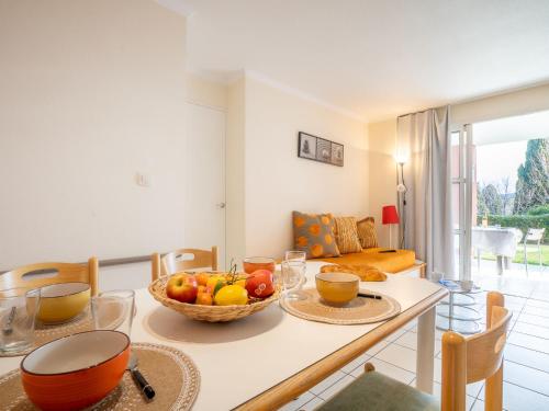 une cuisine avec une table avec un bol de fruits dessus dans l'établissement Apartment L'Esquinade - G1003 by Interhome, à Agay