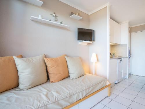 - un salon avec un canapé, des oreillers et une télévision dans l'établissement Apartment L'Esquinade - G4 228 by Interhome, à Agay