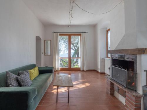 a living room with a green couch and a fireplace at Holiday Home Villa Valentina by Interhome in Serreta